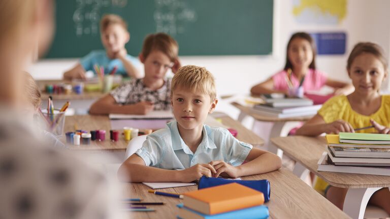 Grundschulkinder sitzen im Unterricht.
