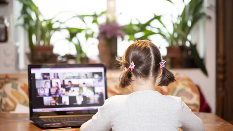 Schülerin nimmt an einer Videokonferenz teil. 