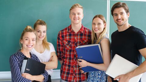 Gruppe junger Lehramtsstudenten vor einer Tafel.
