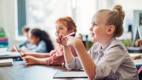 Schülerin sitzt im Unterricht und folgt aufmerksam. 