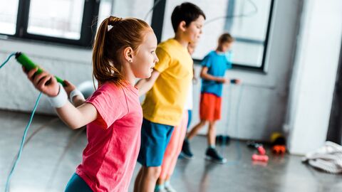 Schülerin und Schüler beim Seilspringen in der Schule. Schülerin und Schüler beim Seilspringen in der Schule.