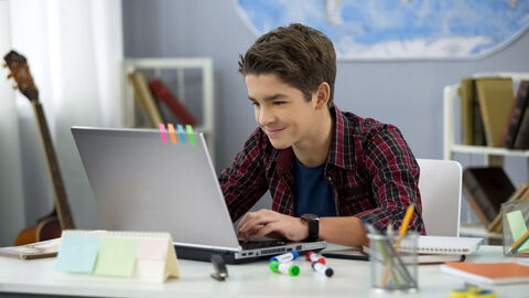 Junge lernt an einem Laptop Junge lernt an einem Laptop