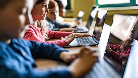 Grundschulkinder sitzen am Laptop. Grundschulkinder sitzen am Laptop.