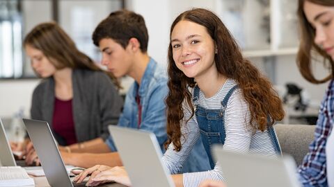 Schülerinnen und Schüler sitzen mit Laptop im Unterricht. Schülerinnen und Schüler sitzen mit Laptop im Unterricht.