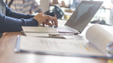 Frau arbeitet an einem Laptop. 