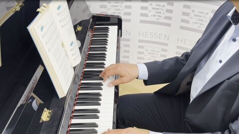 Hände spielen auf einem Klavier