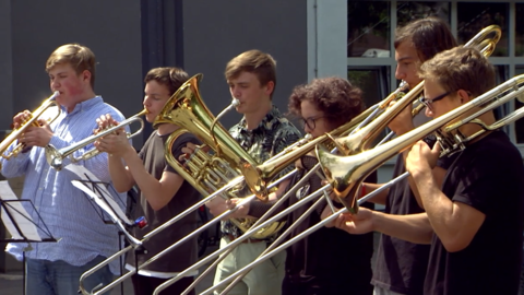 Junge Männer spielen Blasinstrumente