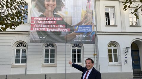 Hessen forciert Kampagne für Lehrkräftenachwuchs Alexander Lorz zeigt auf ein großes Plakat an einer Hauswand