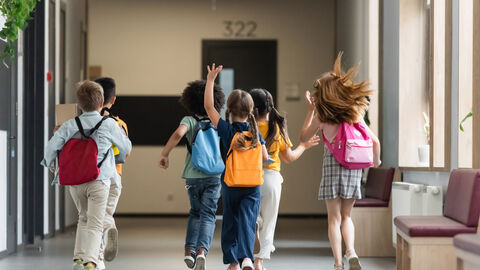 Kinder rennen durch den Flur einer Schule.