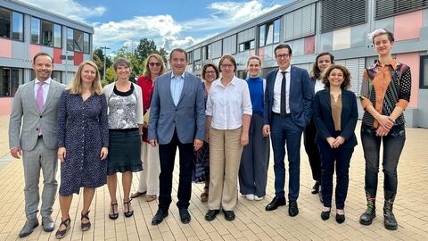 Vorstellung Kompetenzzentrum Bildungssprache Deutsch Kultusminister Lorz mit einer Gruppe Personen vor einem Gebäude. Alle stehen nebeneinander und lächeln.