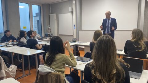 Bildungsminister Schwarz an Wiesbadener Carl-von-Ossietzky-Schule Bildungsminister Schwarz steht vor einer Schulklasse und spricht. Hinter ihm ein Whiteboard, vor ihm Schüler, die ihn anschauen.