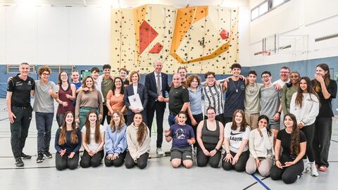 Kultusminister mit Schülerinnen und Schülern in Turnhalle
