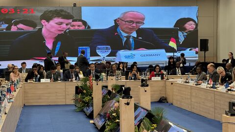 G20-Bildungsgipfel Blick in den Saal des G20-Bildungsgipfels. Überall sitzen Menschen, auf der Leinwand ist Bildungsminister Schwarz zu sehen.