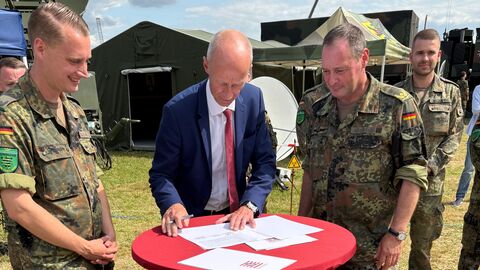 v.l.n.r.: Major Jan Volkmann, Kultusminister Armin Schwarz, Brigadegeneral und Kommandeur des Landeskommandos Hessen, Holger Radmann Eine Gruppe von Personen steht an einem Tisch.