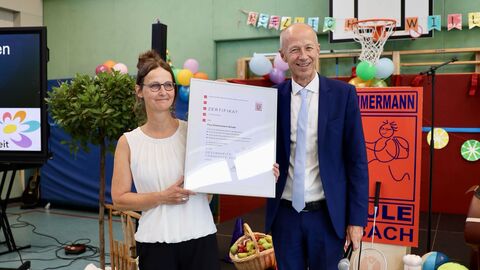 Besuch Paul-Zimmermann-Schule in Korbach Bildungsminister Schwarz steht mit der Schulleiterin zusammen und hat ein Zertifikat überreicht.