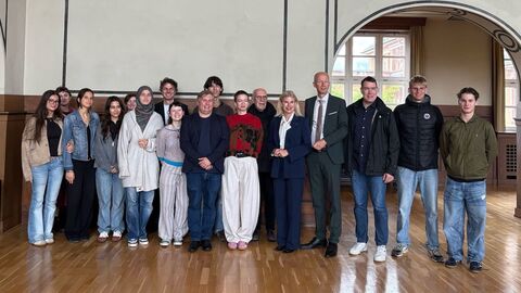 Mehrere Schülerinnen und Schüler stehen zusammen und lachen in Kamera.