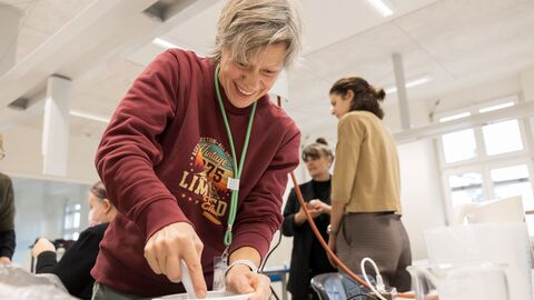Eine Frau stahlt und versucht sich an einem Experiment.