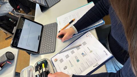 Schülerinnen und Schüler arbeiten im Unterricht mit Tablets an Aufgaben zum Thema Klimawandel und nutzen dabei den KI-Chatbot „telli“ mit verschiedenen Dialogpartnern.