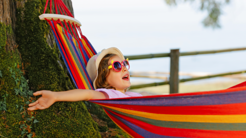 Ein Kind mit Sonnenbrille in der Hängematte